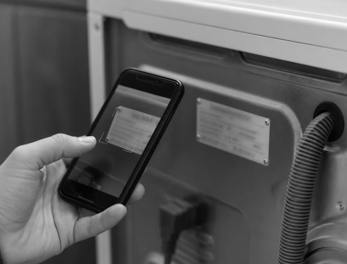 Smartphone scanning the serial number plate on an appliance